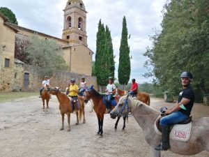 Percorsi imperdibili a cavallo-Veduta del gruppo a cavallo davanti all’Eremo medievale senese-Mi diverto travel